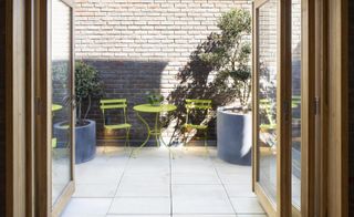living space looking out towards the paved terrace at Southwark brick house by Satish Jassal