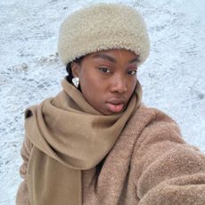 Snow day outfits: Nnenna Echem in cream hat and scarf in snow