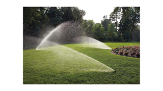 Rain Bird In-Ground Automatic Sprinkler System rotating curtain in action on a lawn