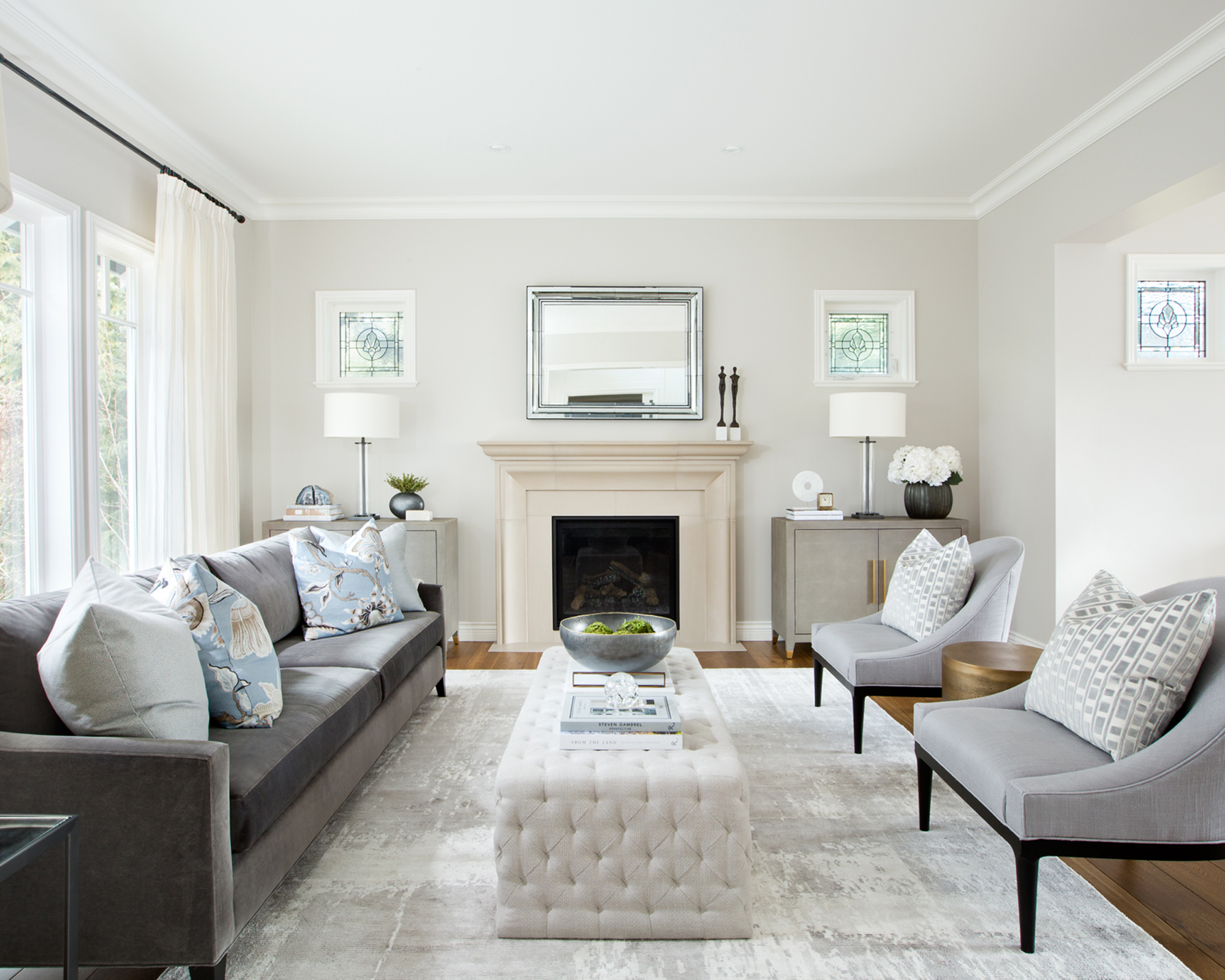 Formal living room ideas with white walls and fireplace, grey sofa and armchairs, and blue accessories