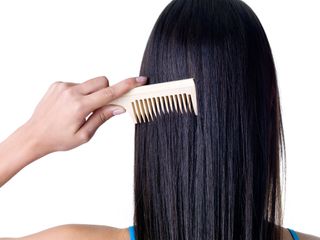 A woman combs her long hair
