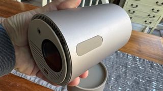 Xgimi MoGo 3 Pro portable projector held in hand above table