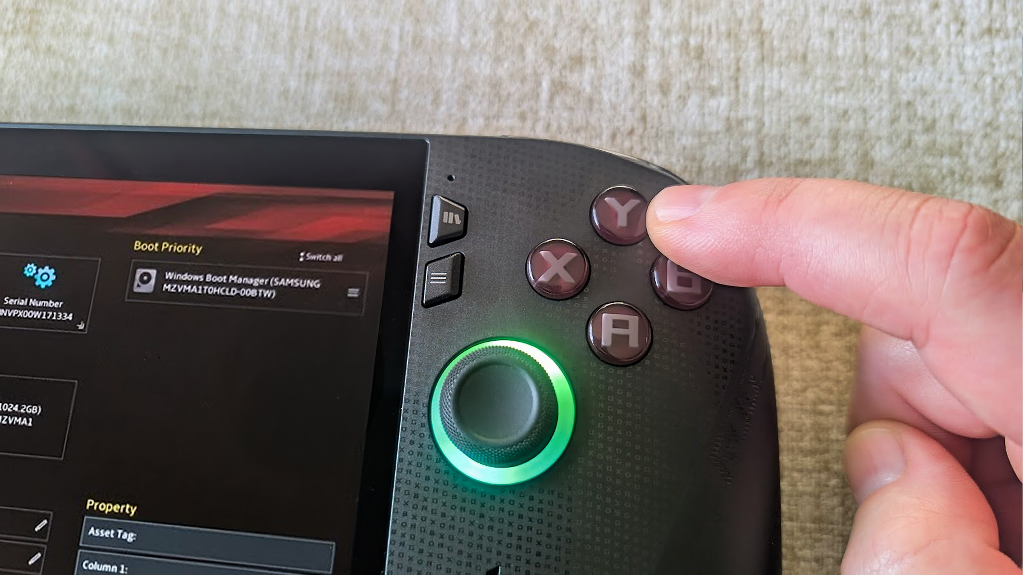 Xbox Ally X showing BIOS and a finger pushing the Y button on the handheld.