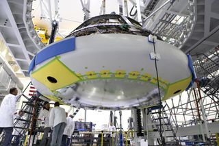 Engineers and technicians install the heat shield on NASA's Orion spacecraft crew module on July 25, 2018, at Kennedy Space Center in Florida.