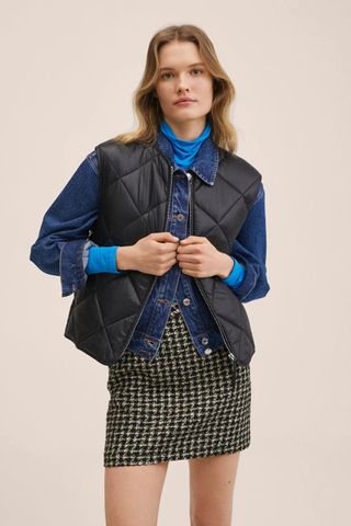 woman wearing a black quilted vest from Mango's sale collection