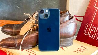 iphone 13 mini leaning against vintage shoes