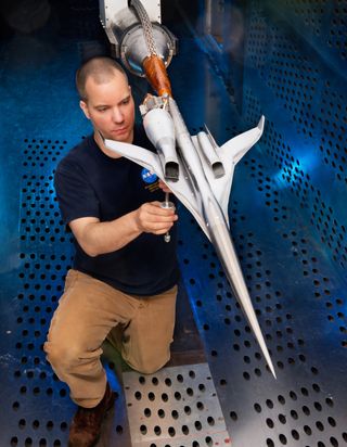 Inside Glenn's 8- by 6-Foot Supersonic Wind Tunnel, technician Dan Pitts inspects Boeing's 1.79% scale model, which shows the two installed flow-through nacelles.