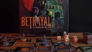 Betrayal at House on the Hill box, models, board tiles, and cards laid out on a wooden table