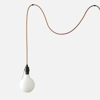 A wall light with cord and industrial lightbulb