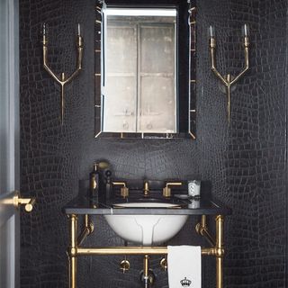 black wall with wash basin and bulb with stand on wall