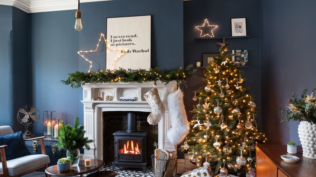 navy blue living room with Christmas tree and fireplace and Christmas stockings hanging on the mantel