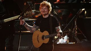 Ed Sheeran holding a guitar on stage during the 37th Annual Rock & Roll Hall of Fame Induction Ceremony