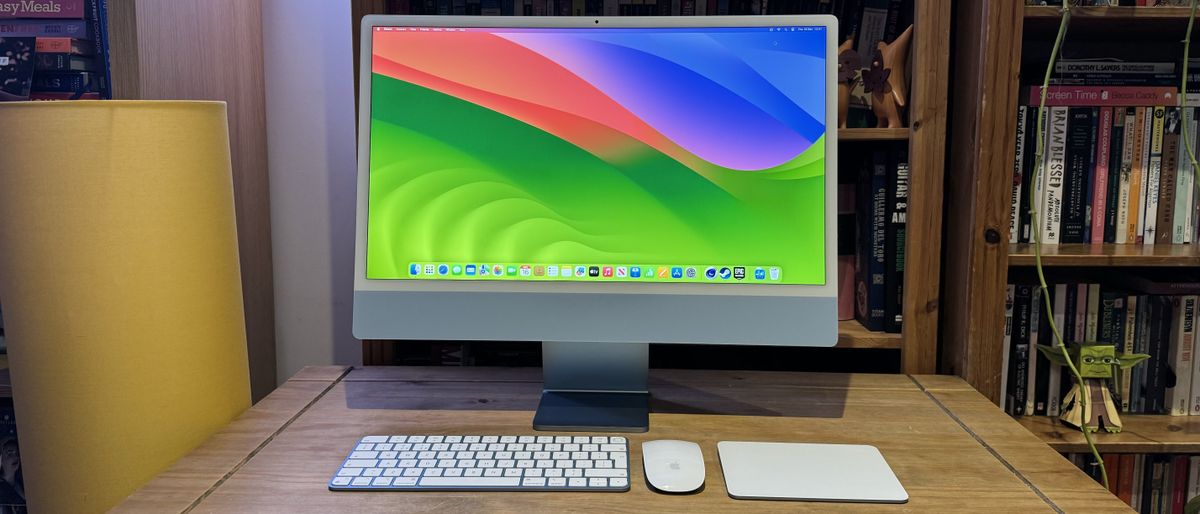 The 2023 M3 iMac on a wooden desk, showing the features of macOS Sonoma