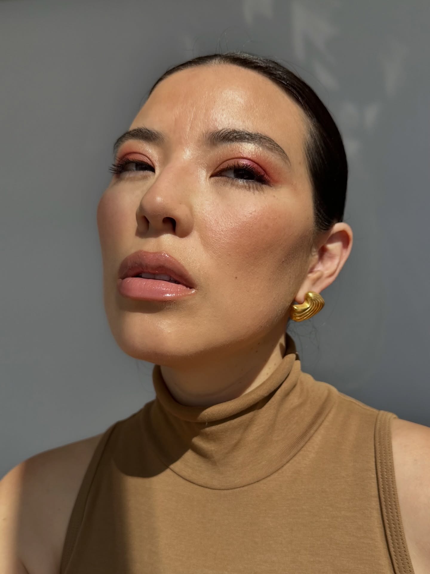 A woman taking a selfie with a pink eyeshadow look