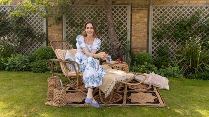 Louise Roe on rattan recliner in garden