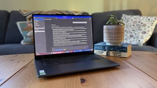 A Lenovo Pro 9n laptop displaying a text-heavy AI workspace sits on a wooden table beside a potted plant on stacked books, creating a calm, cozy living room scene.