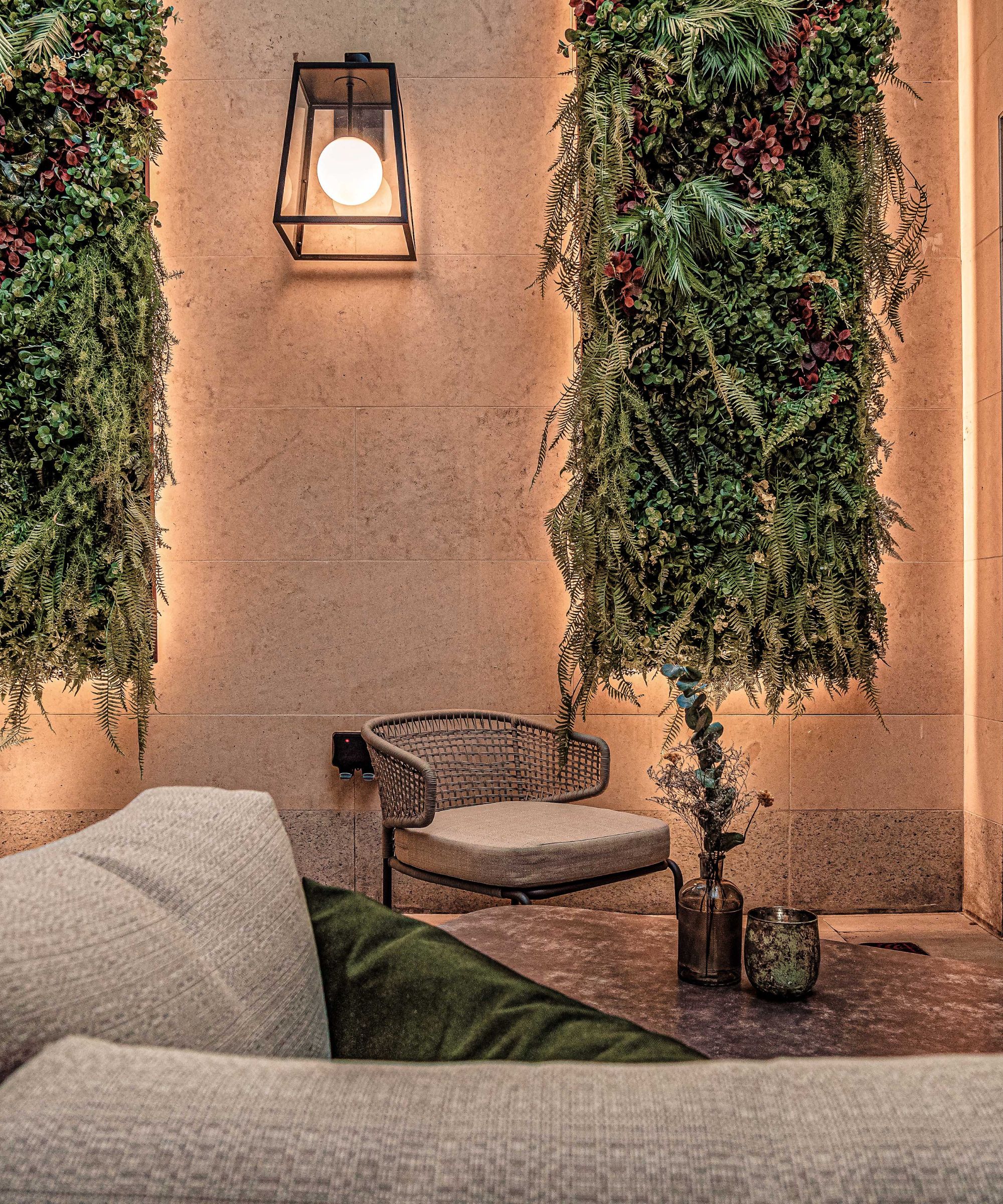 Outdoor terrace with seating, living wall displays and atmospheric lighting