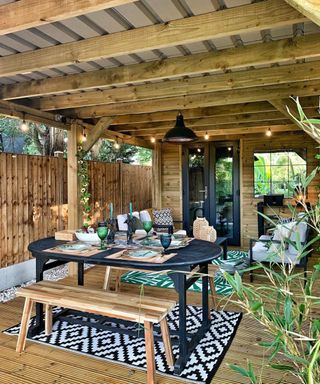 A deck idea in garden room with garden dining table and bench with outdoor rug