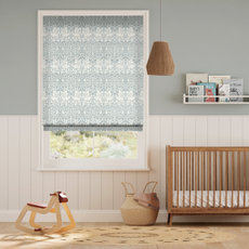 a nursery with blue William morris print blinds over window