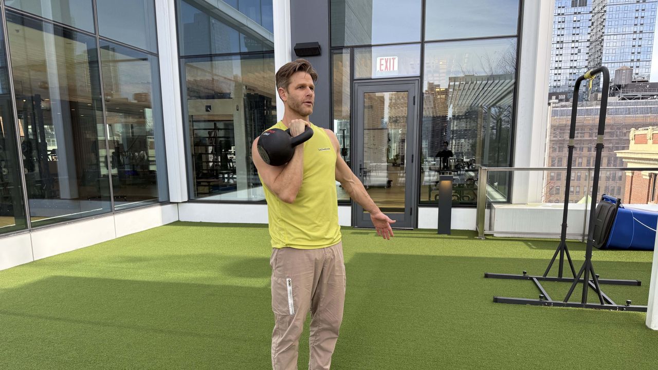 a photo of Peloton trainer Andy Speer doing a kettlebell single-arm press