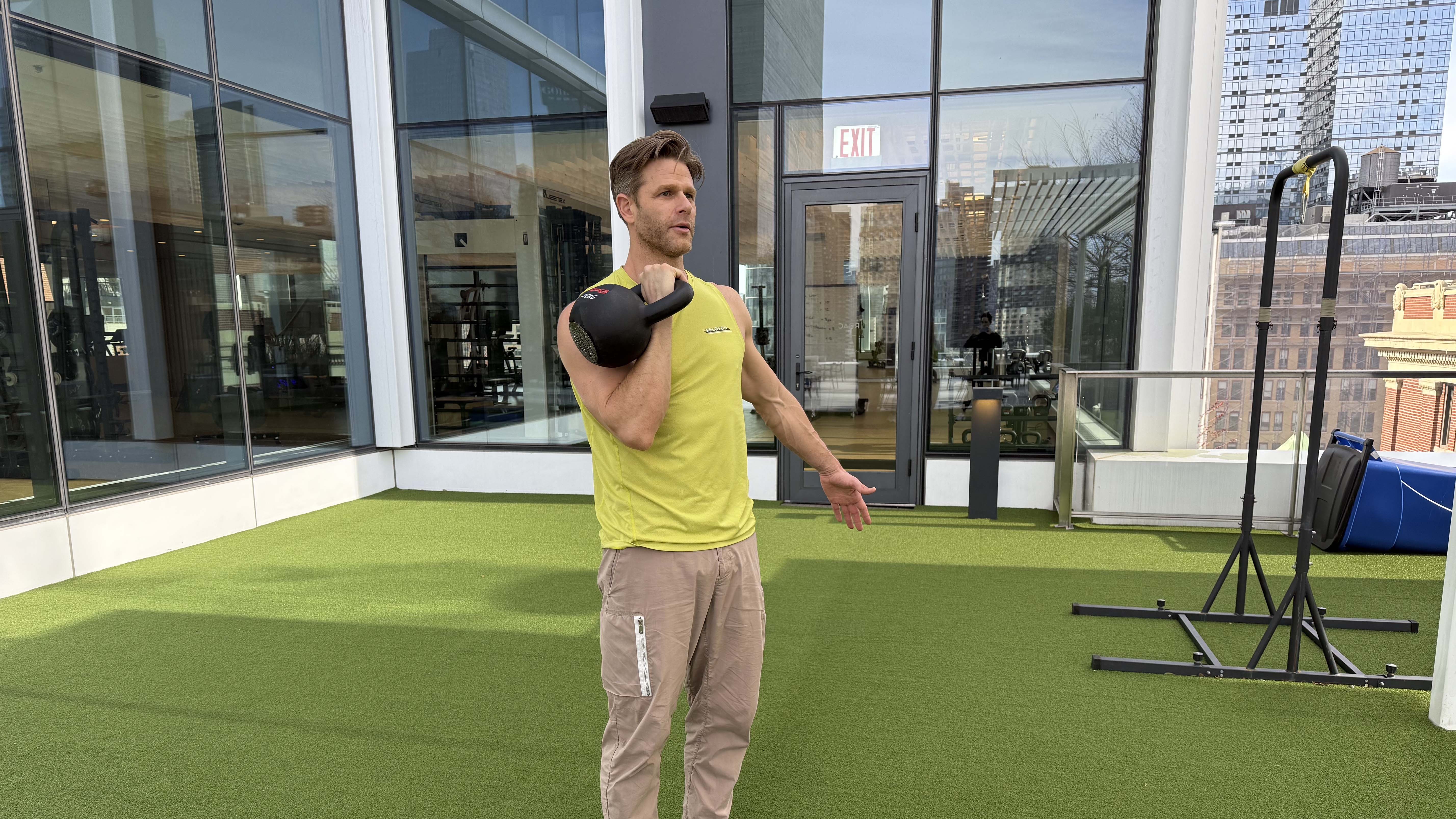 a photo of Peloton trainer Andy Speer doing a kettlebell single-arm press