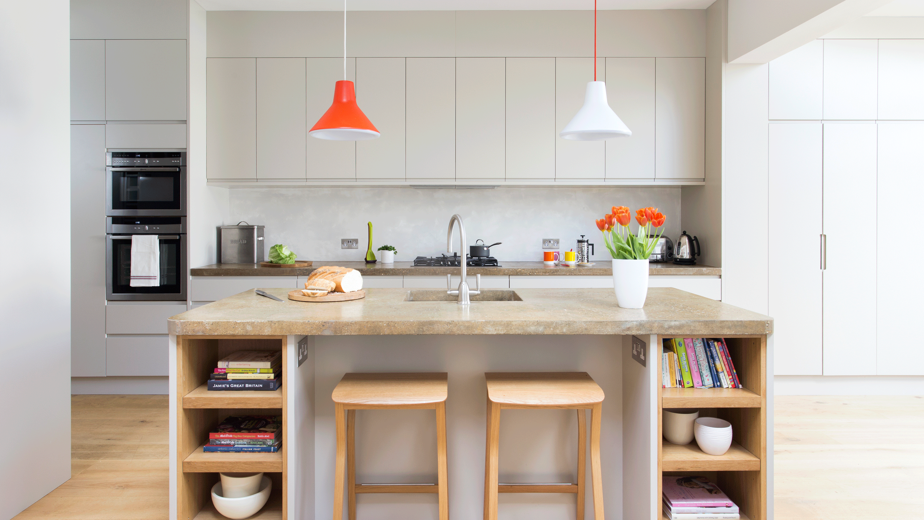 blue kitchen with white worktops and stainless steel oven