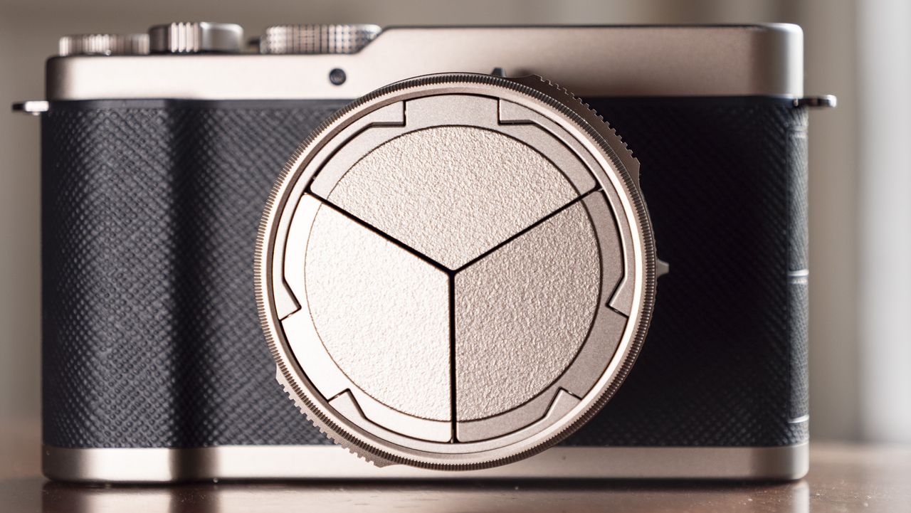 Titanium Gold special edition of the Panasonic Lumix L10 compact camera, on an antique wooden table