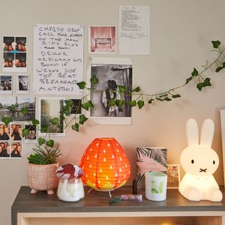 Bedroom with hanging photos, vines, and lights with decorative items on shelf