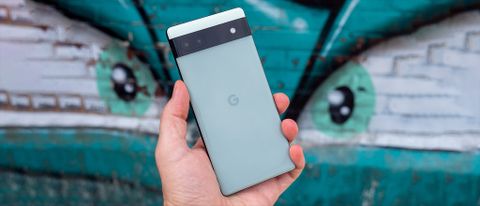 Wide version of holding a Google Pixel 6a in front of graffiti eyes