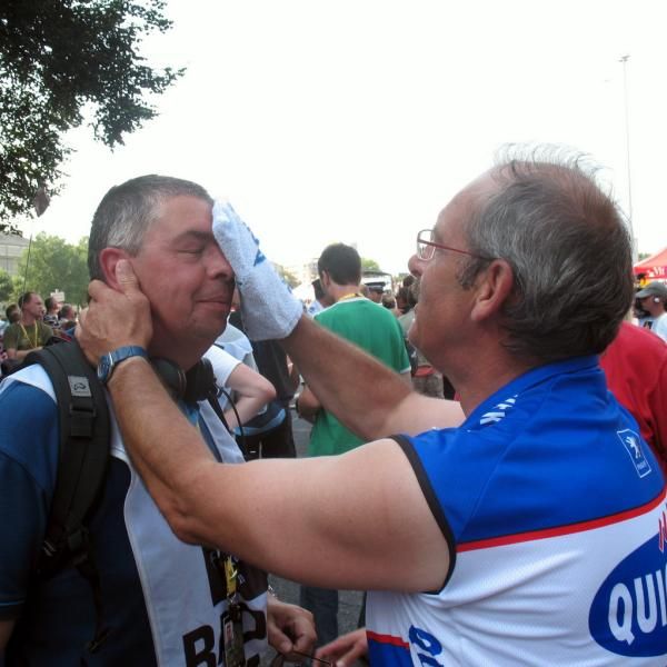 Dirk Nachtergaele isn't only taking care of his riders, but also Belgian TV-reporter Carl Berteele is freshened up while awaiting the grupetto after a day on the motorbike