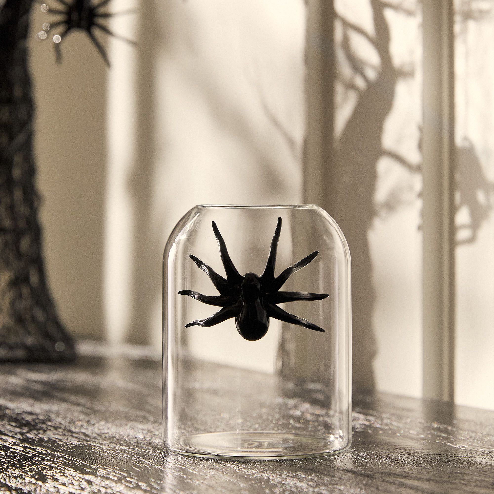 a vase with a black spider on the outside