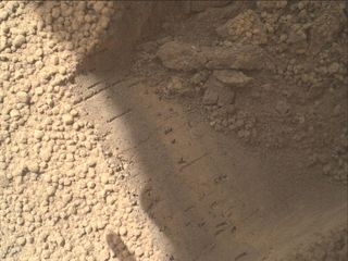 This image shows part of the small pit or bite created when NASA's Mars rover Curiosity collected its second scoop of Martian soil at a sandy patch called "Rocknest." This image was taken by the Mars Hand Lens Imager (MAHLI) camera on Curiosity's arm during the 69th Martian day, or sol, of the mission (Oct. 15, 2012).