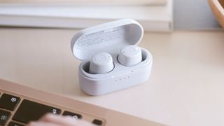 The Yamaha TW-E3C earbuds in their case on a desk