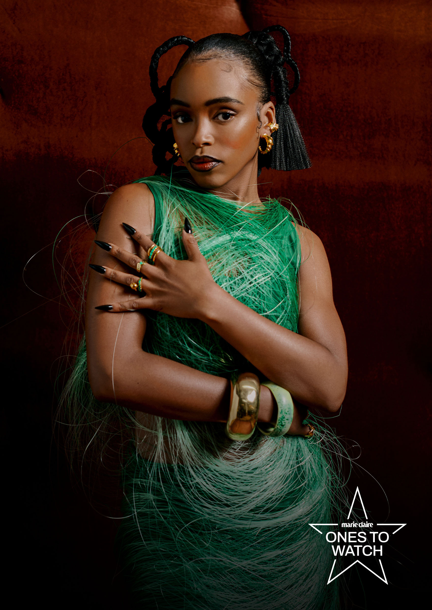 actress lovie simone poses wearing a green dress and chunky jewery