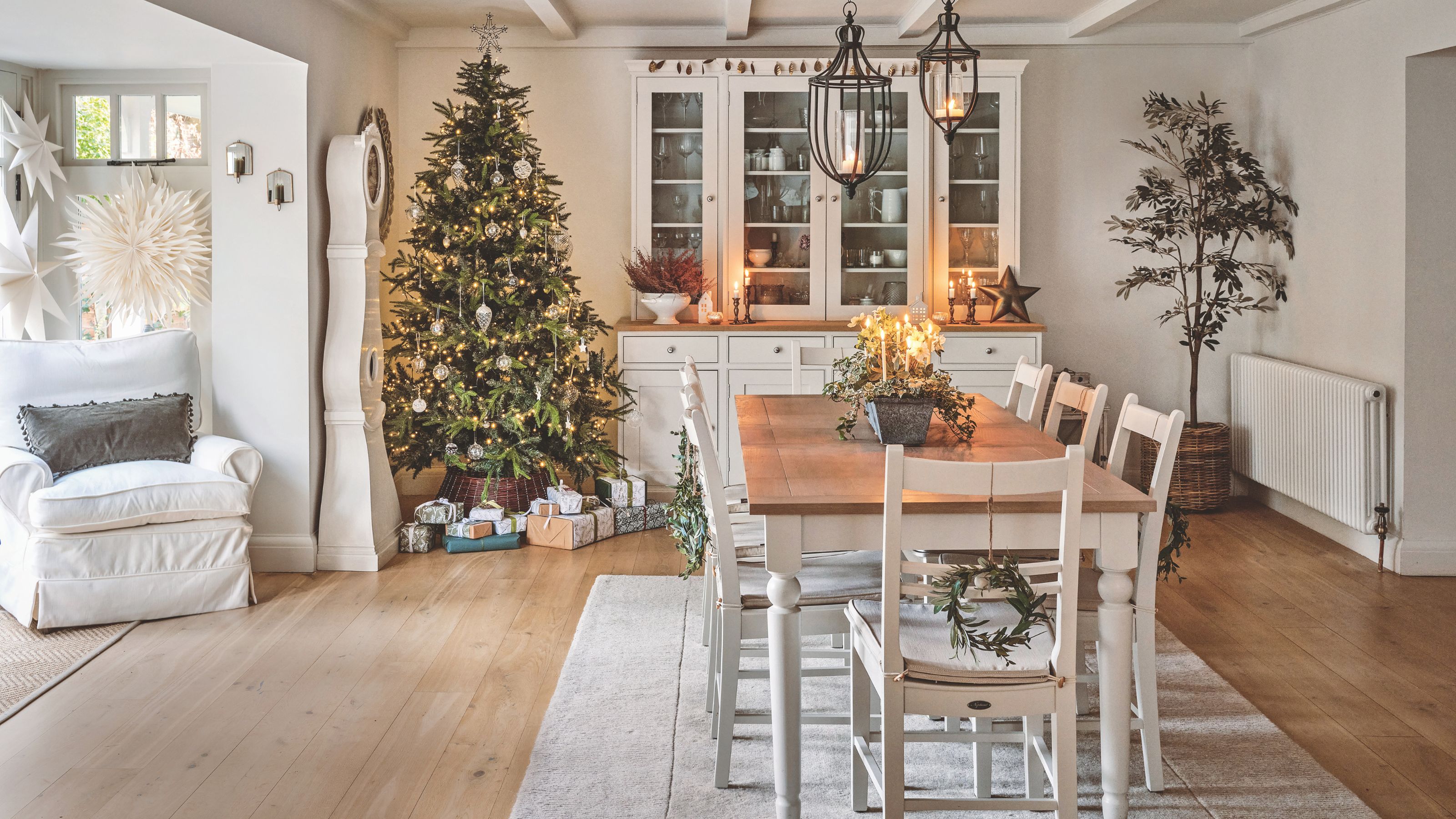 Dining room with a christmas tree in the corner, and a dining room table in the middle of the room