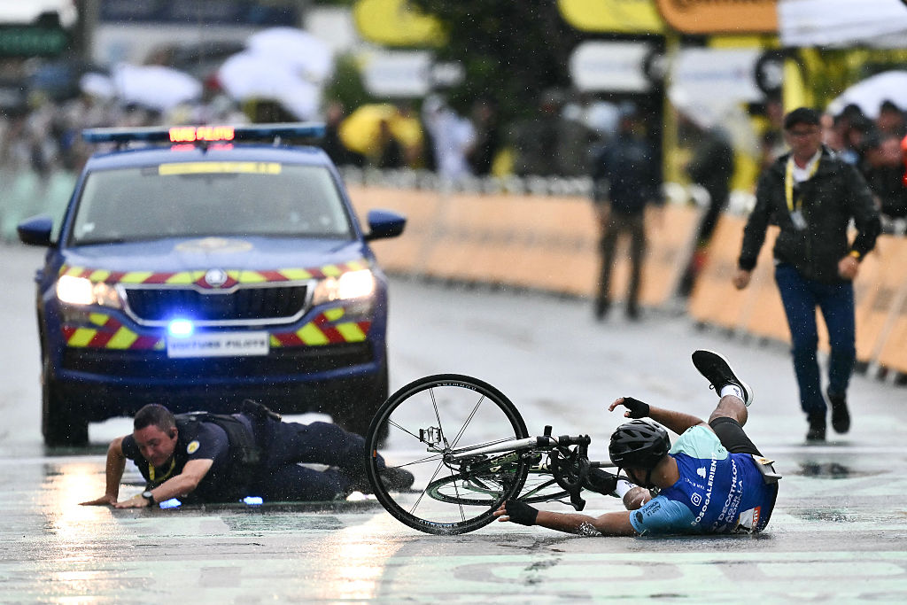 A French Republican Security Corps (CRS - Compagnies Republicaines de Securite) officer tackles an individual attempting to cycle across the finish line minutes before the final sprint of the 112th edition of the Tour de France cycling race, 160.4 km between Bollene and Valence, southern France, on July 23, 2025. (Photo by Marco BERTORELLO / AFP)