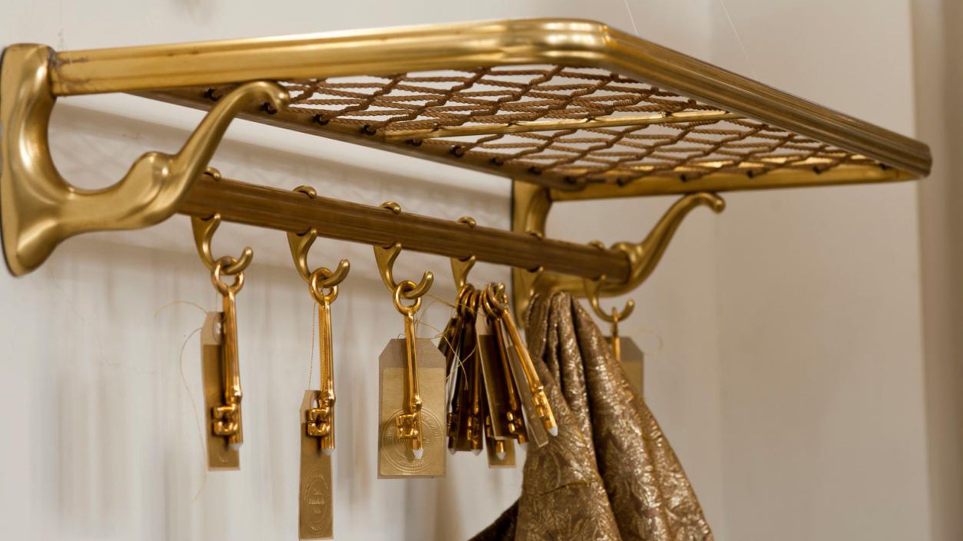 Vintage brass rail carrage storage rack in hallway to consider how to clean brass