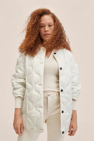 woman wearing a white quilted jacket from Mango's sale collection