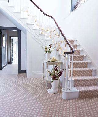 White staircase with pink spotted carpet and matching stair runner design