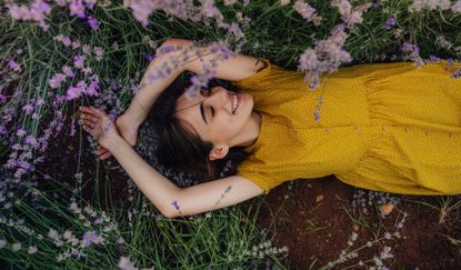 Photo of a smiling young woman lying in lavender
