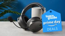 Audeze Maxwell sitting on a white desk with a blue wall in the background.