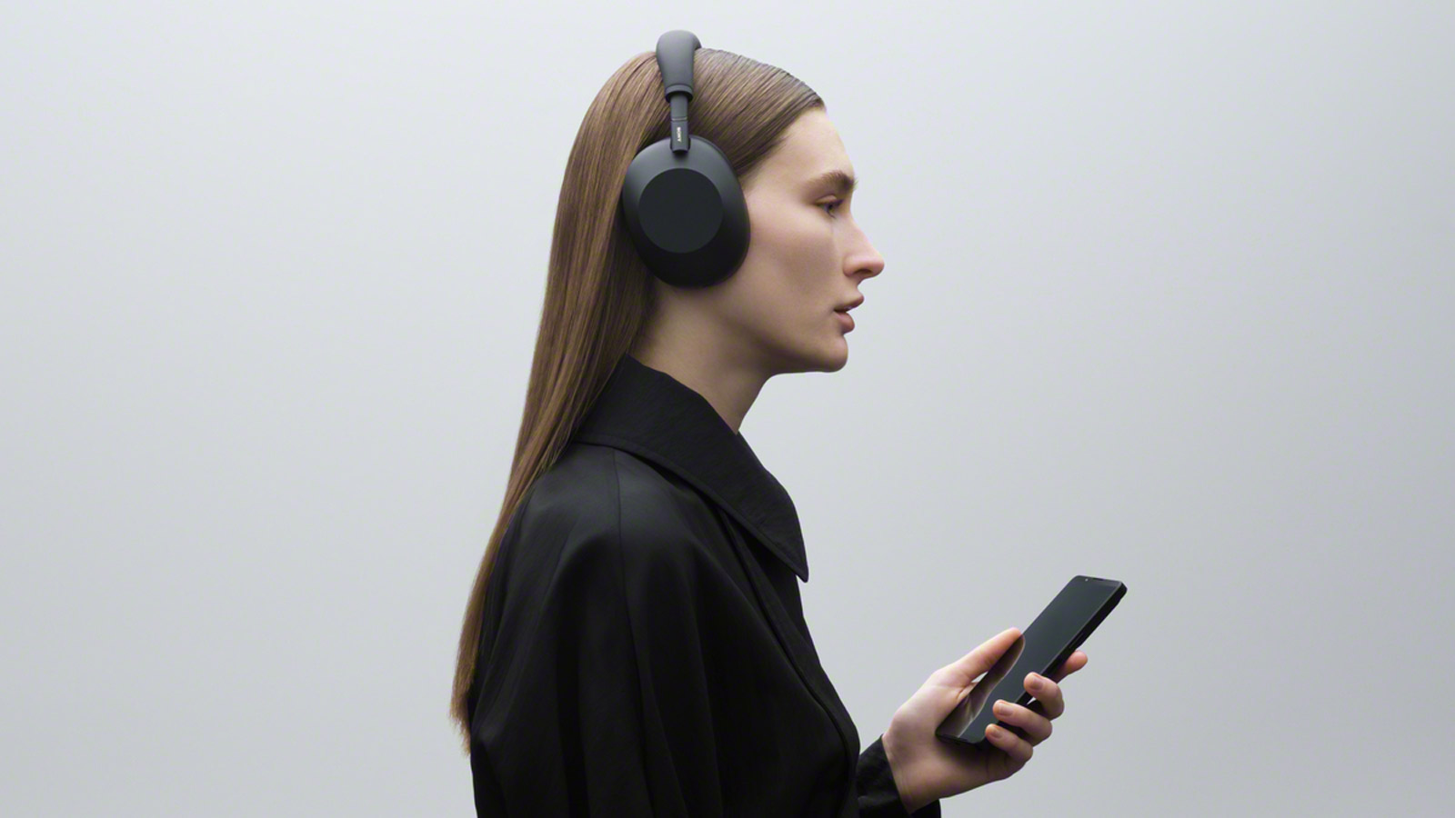 A woman wearing the Sony WH-1000XM6 headphones.