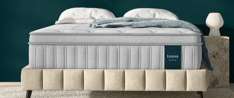 Image shows the Leesa Chill Oasis Mattress placed on a luxurious cream quilted bed frame, placed in a teal coloured bedroom