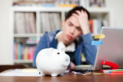 Piggy bank with young man worrying in background