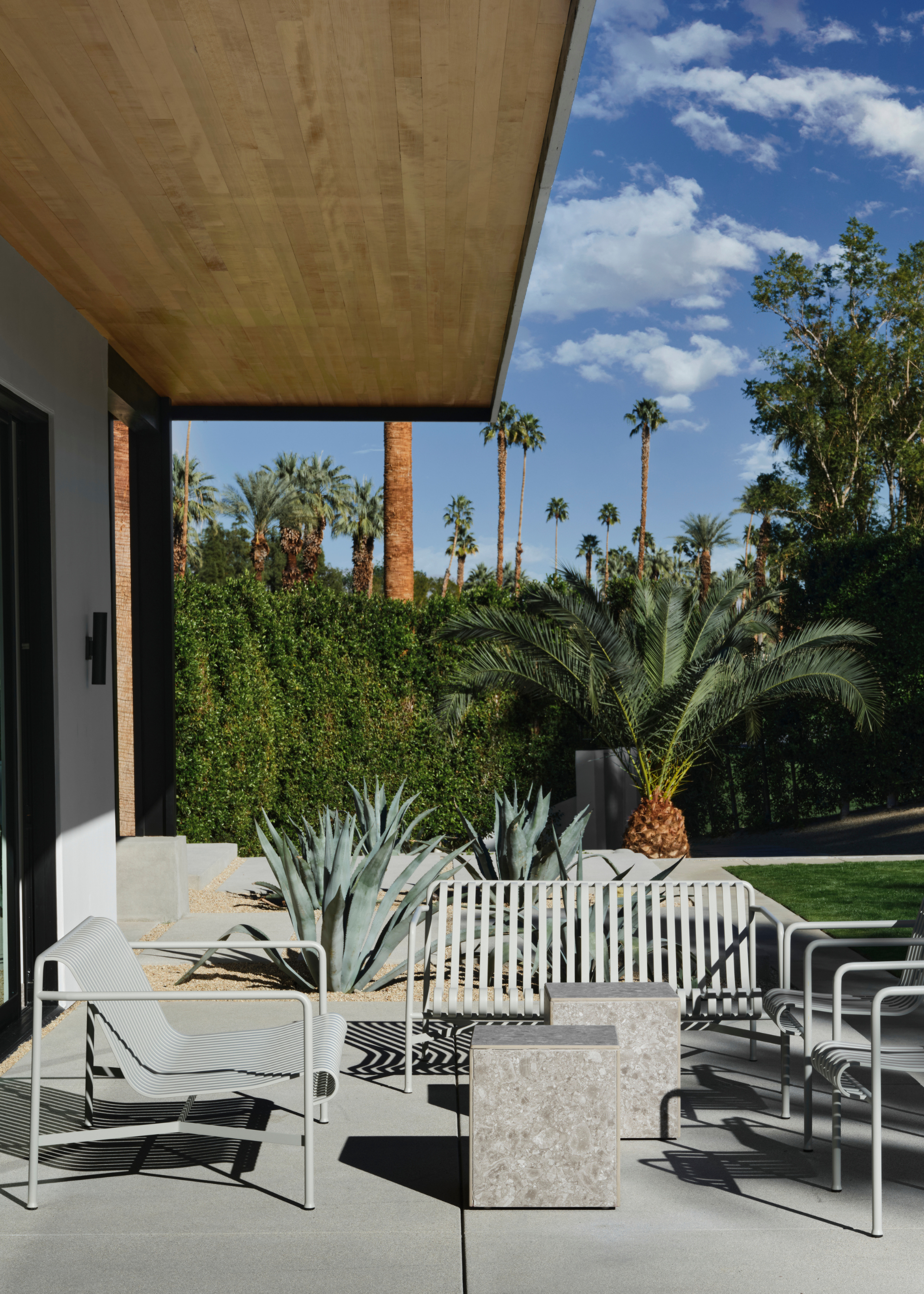 A backyard with muted outdoor furniture and cubed side tables