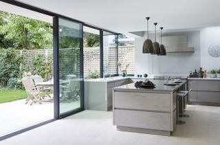 an open plan kitchen with large sliding doors out to the garden