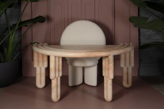 Semi-circular marble desk with white chair featuring a round back