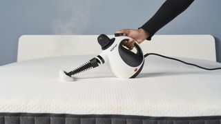 Koitat mattress steam cleaner in use on white mattress