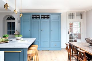 Characterful spacious kitchen diner with Georgian bespoke carpentry in bright blue, storage and a kitchen island