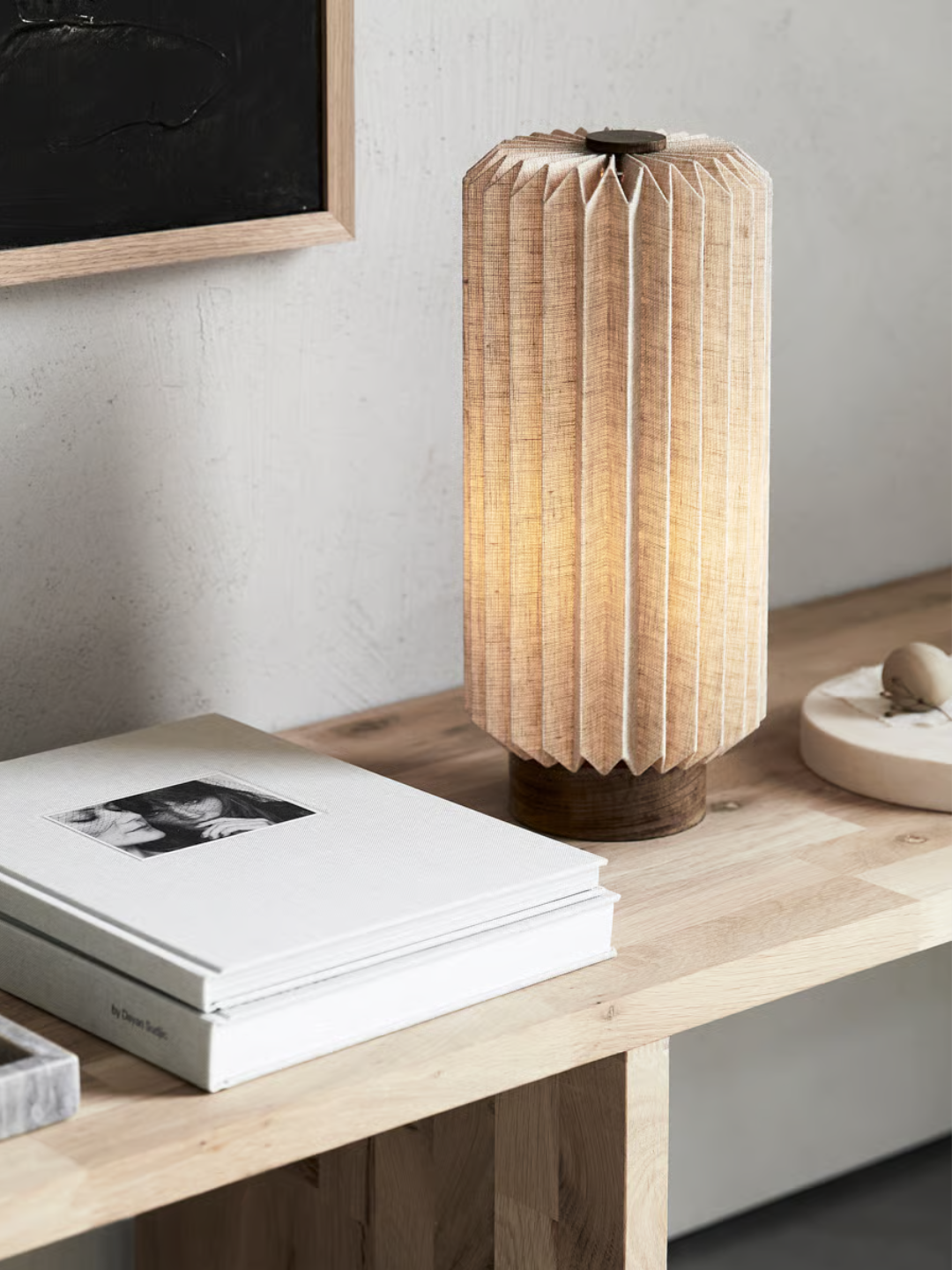 A brown fabric lamp on a side table by books